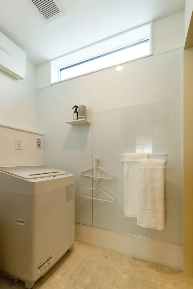 脱衣兼ランドリースペースは一面をマグネットボードにして壁面を活用。