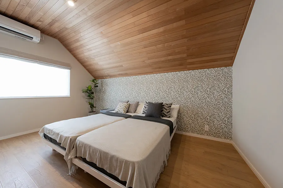 板張りとアクセントクロスが調和した、安らぎの主寝室